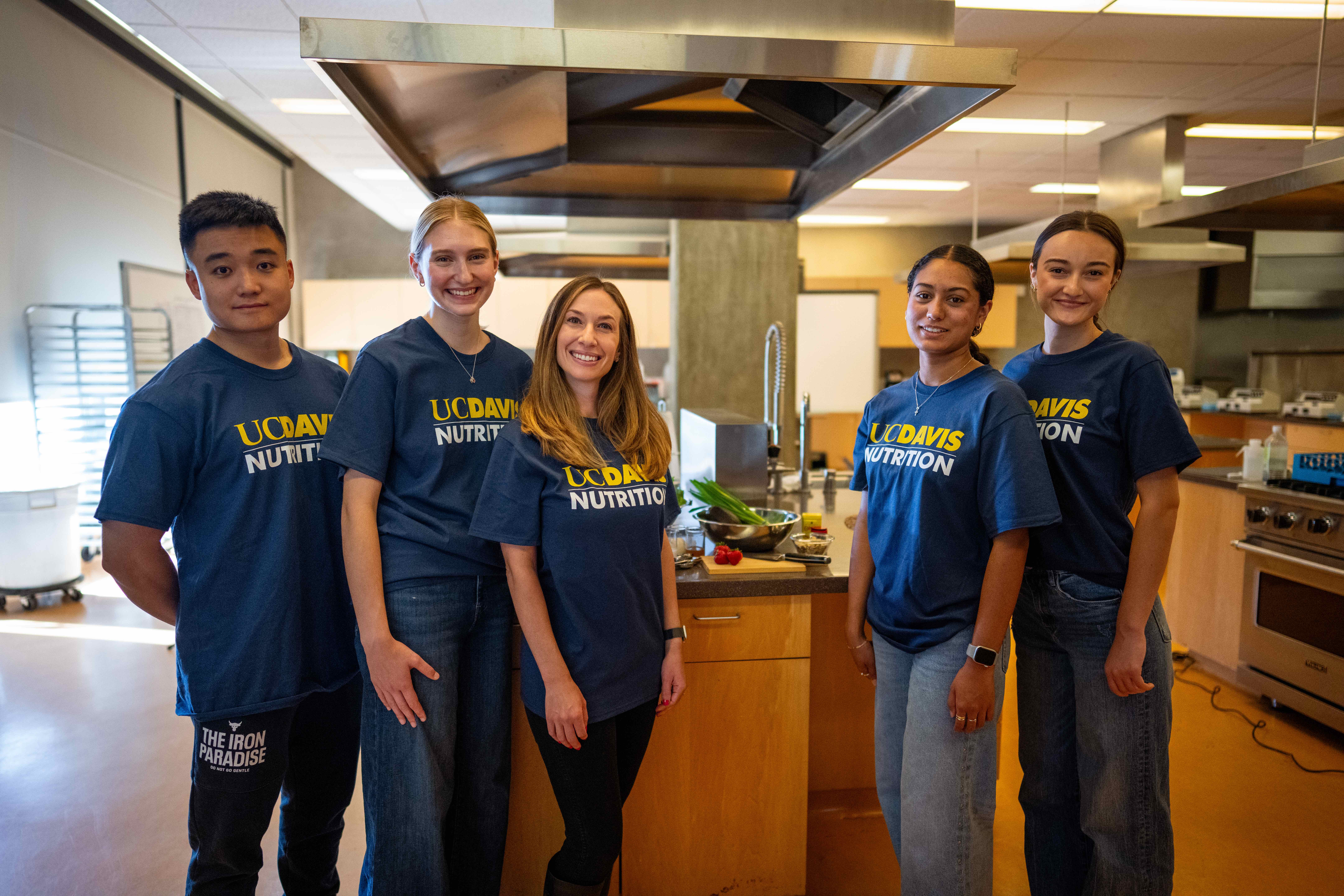 Four students and faculty member stand in kitchen at the Food Innovation Lab on campus