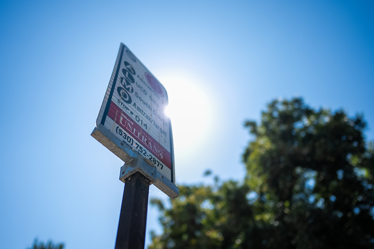 A bus sign against a blue sky.