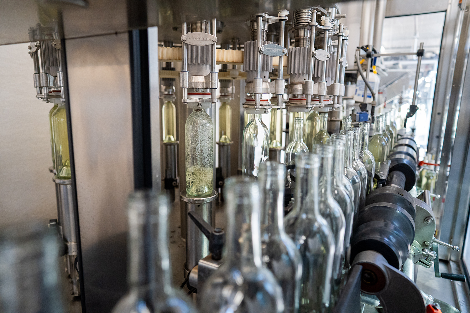 Empty bottles being filled with sauvignon blanc on a mobile bottling line, which students learn to use as part of a winemaking course. (Jael Mackendorf / UC Davis)