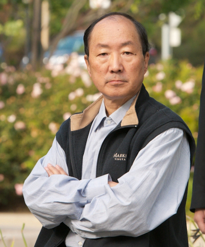 An older gentleman with arms crossed.