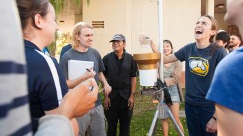 Our faculty try to make learning fun. This atmospheric science professor and his class share a laugh as they learn how to read a rain catcher.