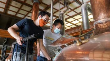 Charlie Thudium, left, and Baoluo Gao observe their ale-in-the-making at Sudwerk Brewing Co. (Karin Higgins/UC Davis)