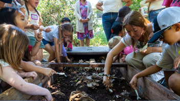 Students look at the compost bin.