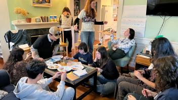 People sit together talking in a room.