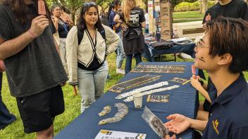 A MANRRS student sits at a table while answering questions at an event.