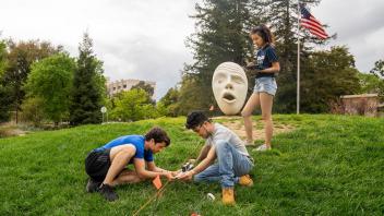 Landscape Architecture students conducting class assignment on grading on the hill in front of Mrak Hall.