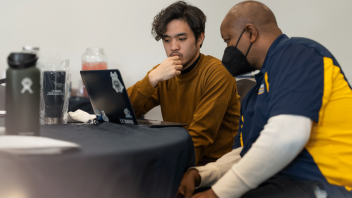 A UAP advisor and student talk together during the Slice of Advising event.