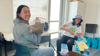 Students hold up bags of dog food.