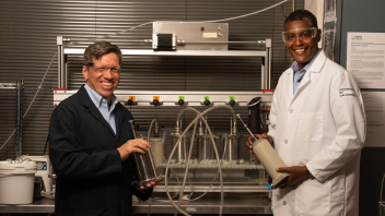 Ermias Kebreab and Matthias Hess stand together in the Hess lab that does work that mimics a rumen digestive system or cow digestive system.