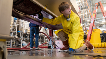 Wolfgang Peterson, a viticulture major, goes into the tank and washes out all the left over grape skin and seeds out for cleaning the grape crusher.