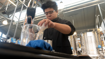 Lanqing Xiao, a viticulture major, pulls wine samples to test the sugar levels.