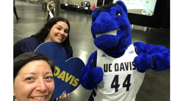Two students take a selfie with Gunrock.