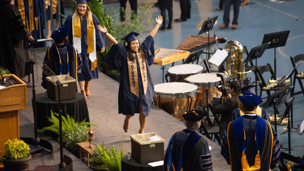 Students walking across the graduation stage.