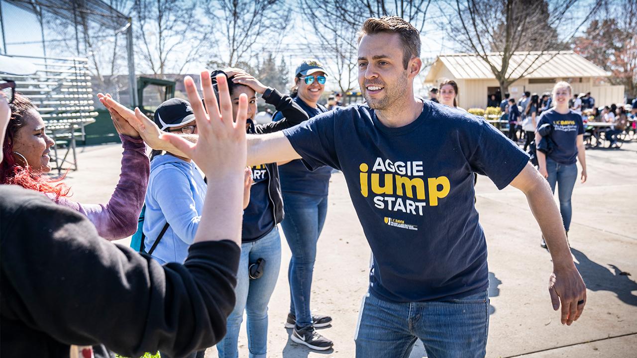 Aggie Jumpstart staff leader high fives a student.