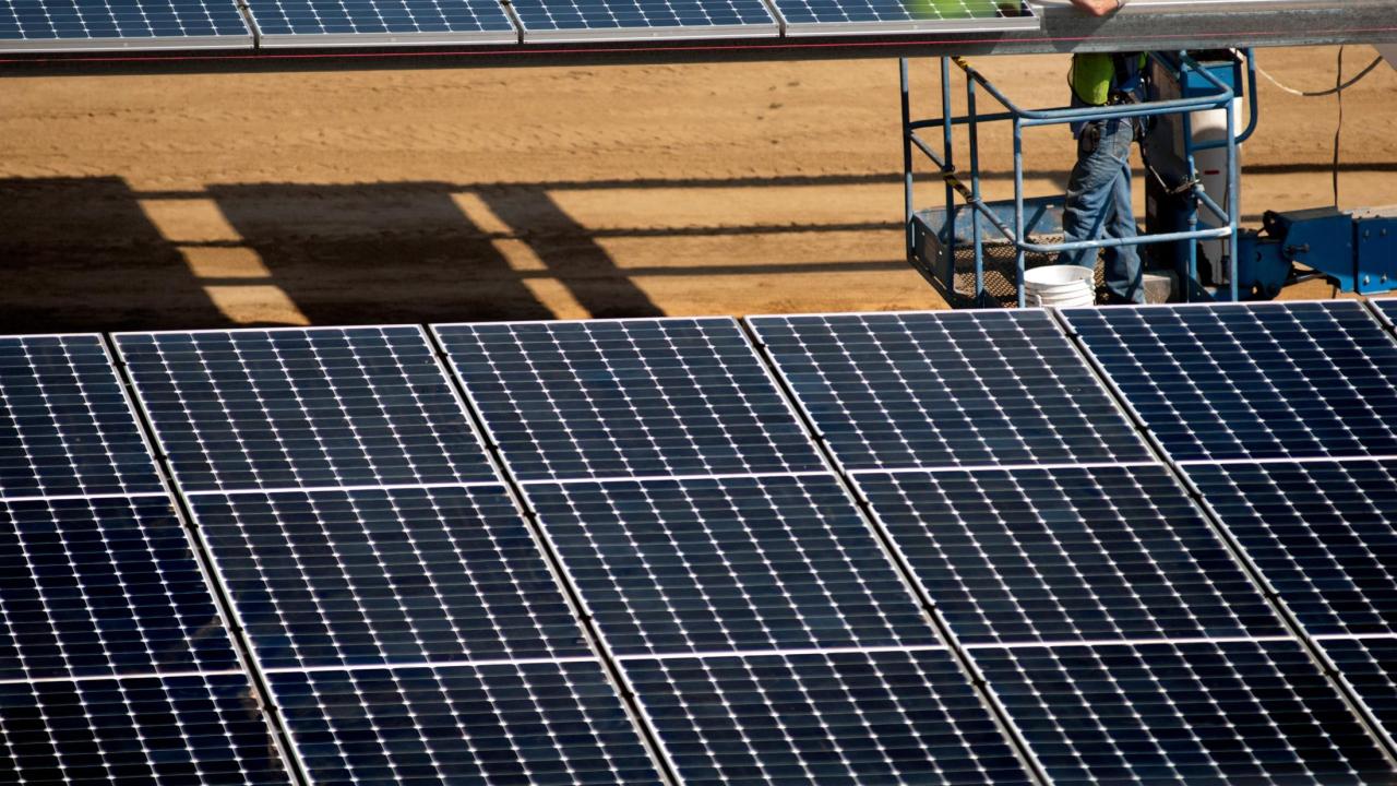 Workers install the parking lot solar panels at West Village at UC Davis in Davis, CA.