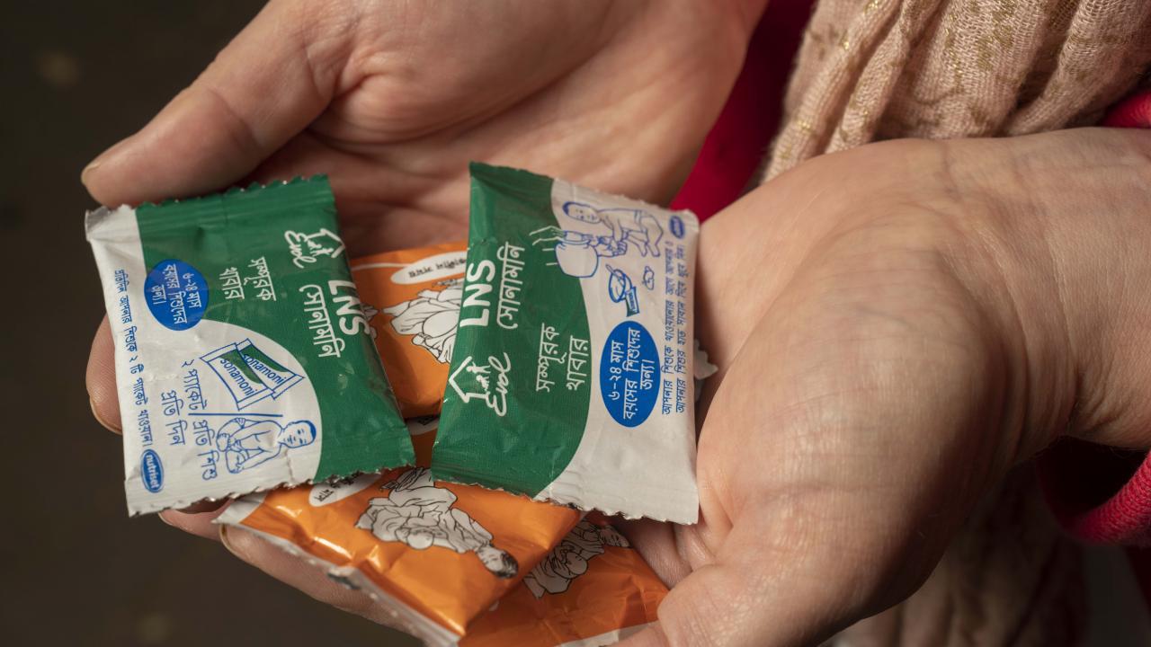 Christine Stewart holds packets of lipid-based nutrient supplements, a paste that typically includes oil, peanut butter, milk powder, vitamins and minerals. (Karen Higgins/UC Davis)
