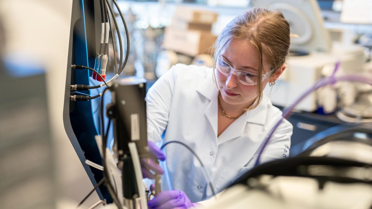 A graduate student working with a bioreactor used in protein separation and meat cultivation. (Jael Mackendorf / UC Davis)