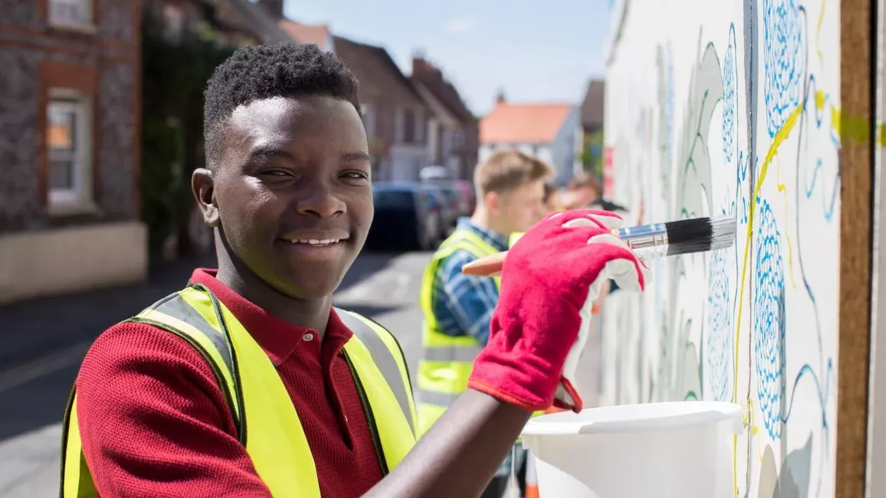 Students paint a community mural project. (Getty Images)