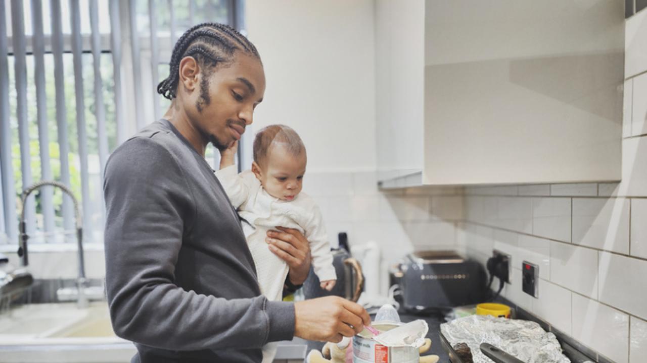 A father with baby in a kitchen.