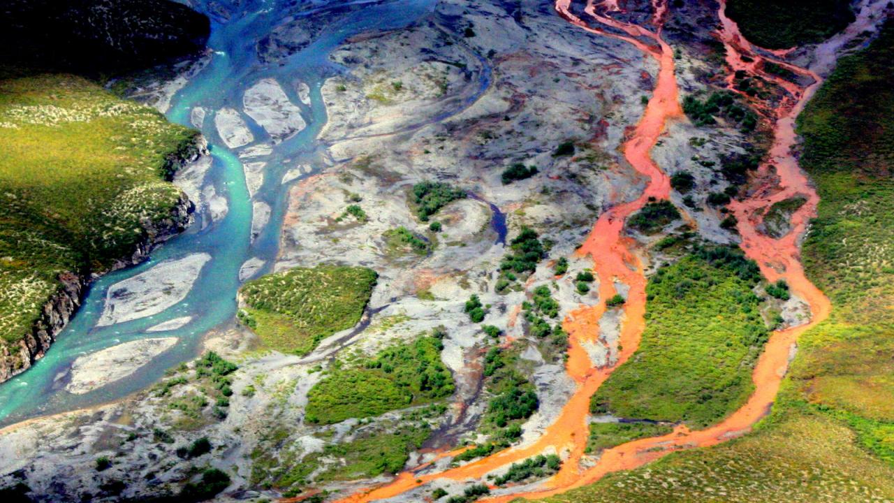 An aerial view of the rust-colored Kutuk River in Gates of the Arctic National Park in Alaska. Thawing permafrost is exposing minerals to weathering, increasing the acidity of the water, which releases metals like iron, zinc and copper. (Ken Hill / National Park Service)