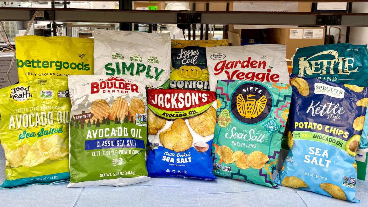 Assorted colorful potato and veggie chip bags lined up on a counter