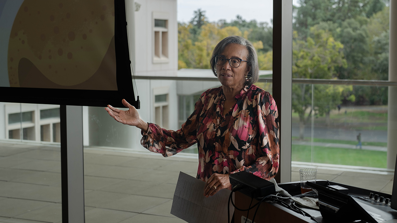A person standing beside a lectern.