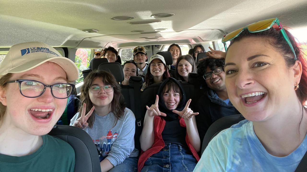 A group of people smiling in a bus together.