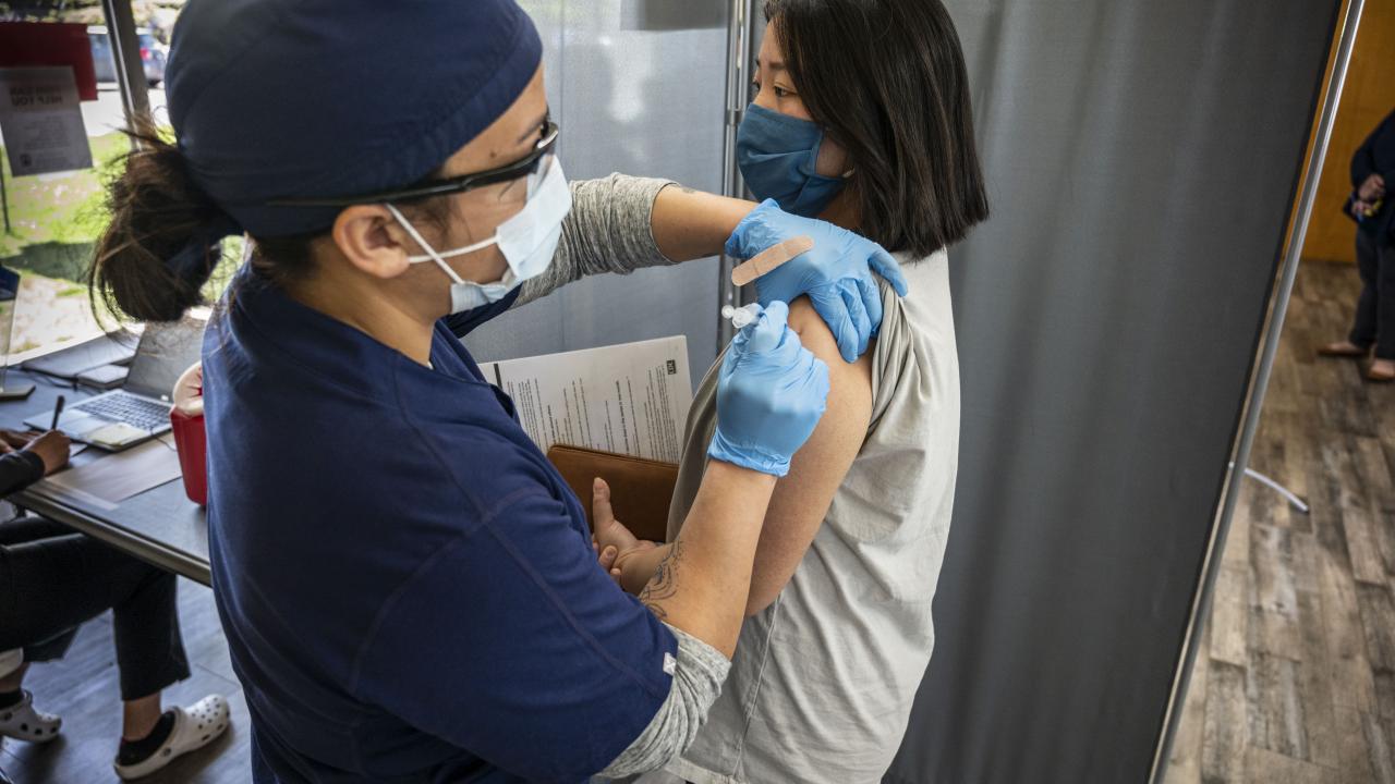A woman receives her COVID-19 vaccine shot at a clinic.