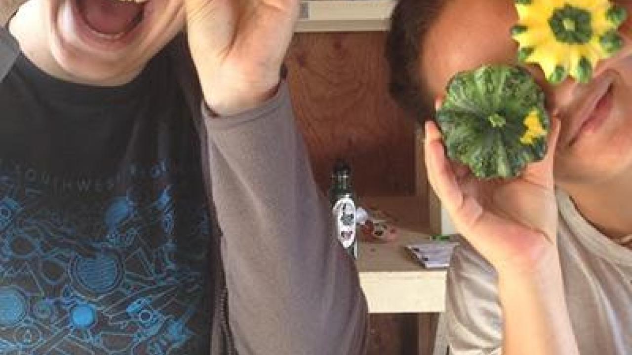 Two students taking a photo with squash.