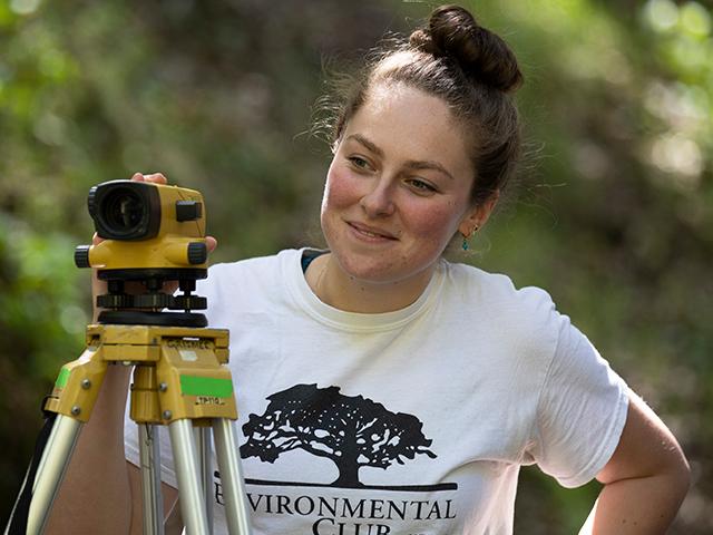 Student with surveying equipment.