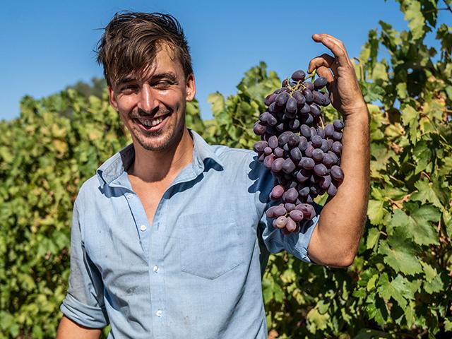 Student holding up grapes.