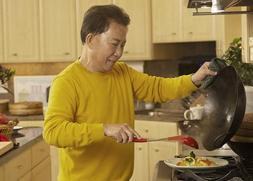 Martin Yan plates stir fry made in his first wok. (Gregory Urquiaga/UC Davis)