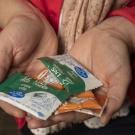 Christine Stewart holds packets of nutrient supplements. They are typically a mixture of a legume — peanut, lentil or chickpea paste — plus milk powder, oil, and a full complement of the vitamins and minerals children need. (Karin Higgins/UC Davis)
