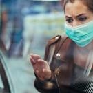A woman looks into a grocery counter while wearing a mask.