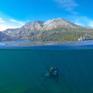 Katie Senft of the UC Davis Tahoe Environmental Research Center dives in the still-blue waters of Lake Tahoe, where clarity levels have stabilized since the 1990s. (Brandon Berry/UC Davis)