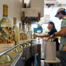 Students taking wine bottles off a mobile bottling line and placing them in boxes for future use. (Jael Mackendorf / UC Davis) 