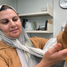Rasha Aldamrat, a staff research associate at Foundation Plant Services, with a grape plant grown from a sample where the virus was removed so the plant is "clean." This plant is about 8 months old. (Emily C. Dooley / UC Davis)