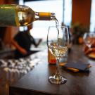 Wine pouring into a glass with a restaurant as background