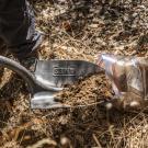 A shovel is used to scoop dirt into a ziploc bag for testing.