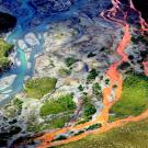 An aerial view of the rust-colored Kutuk River in Gates of the Arctic National Park in Alaska. Thawing permafrost is exposing minerals to weathering, increasing the acidity of the water, which releases metals like iron, zinc and copper. (Ken Hill / National Park Service)