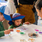 Children create beautiful art with the help of some colorful maggots at this 2025 Picnic Day event. (Jael Mackendorf/UC Davis)