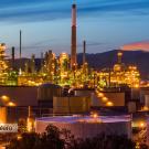 An oil refinery set against a sunset