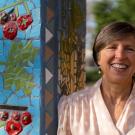 Wolf Prize recipient Pam Ronald outside Robbins Hall, leaning against pillar decorated with a ceramic mosaic mural. (Joel Mackendorf/UC Davis)