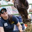 A person feeding a horse at Picnic Day in the Cole Facility.