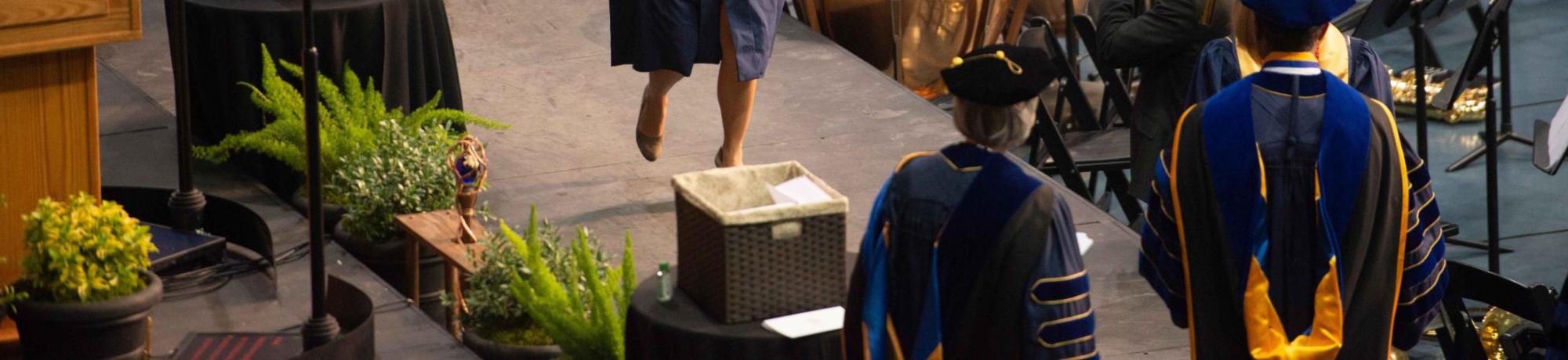 Students walking across the graduation stage.
