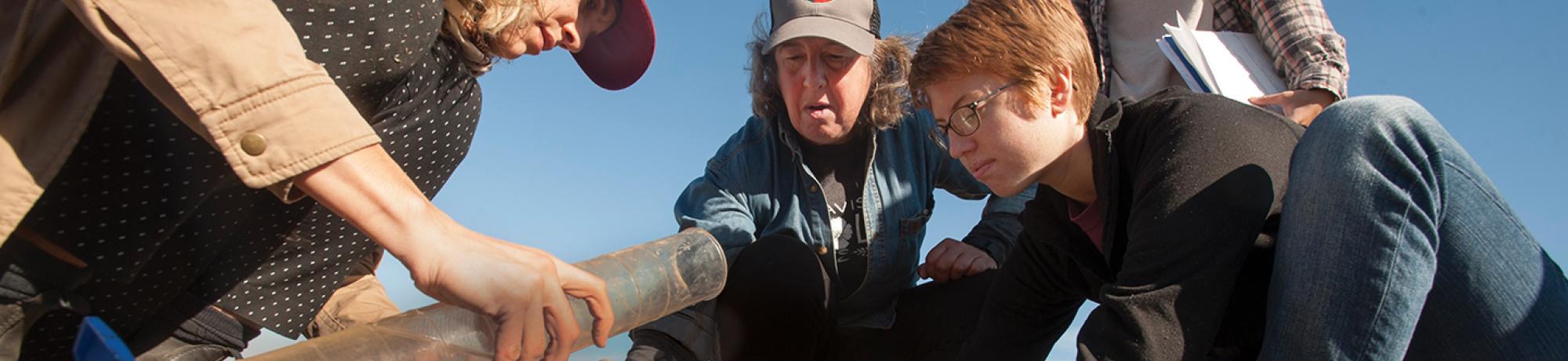 Faculty and students studying soil.