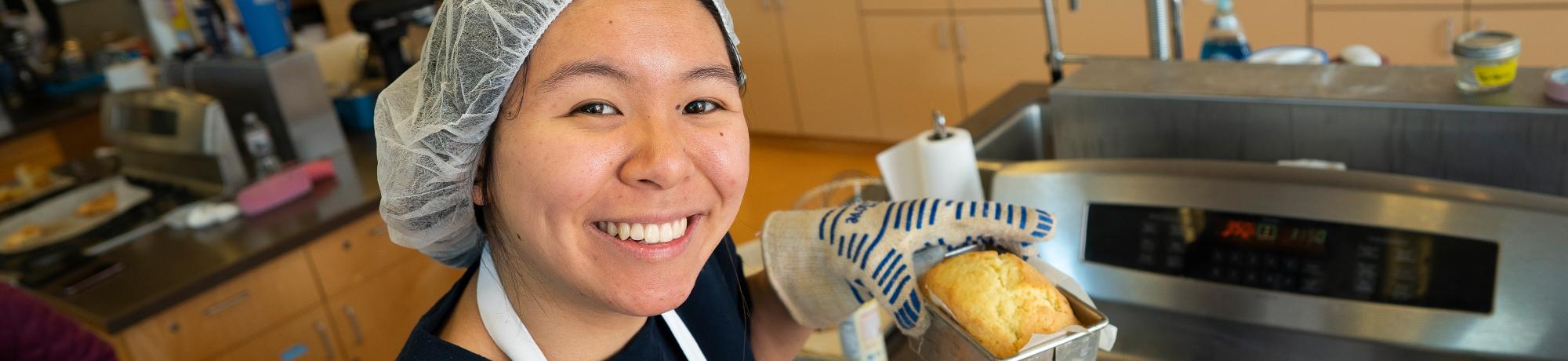 A food science student baking cake during a class.