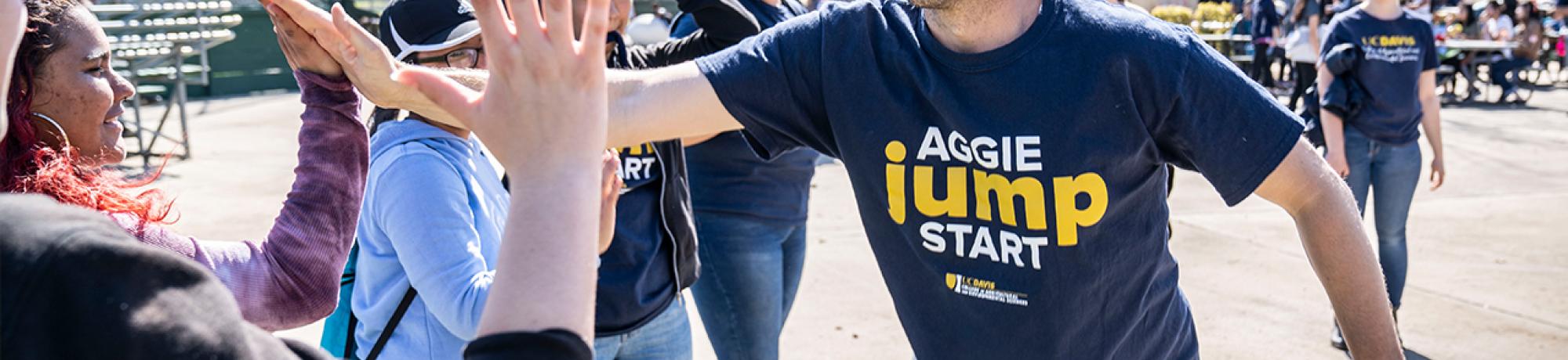 Aggie Jumpstart staff leader high fives a student.