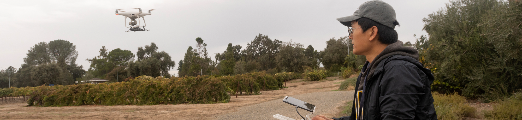 An individual operating a quadcopter drone outdoors.