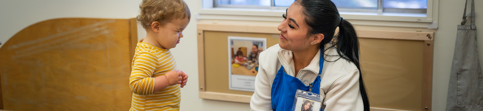 A child makes a face while playing pretend with an adult.